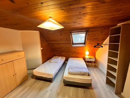 ラ・ブルブールにあるAppartement Duplex avec Wifi proche du centreの木造キャビン内のベッドルーム1室(ベッド2台付)