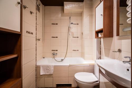 łazienka z wanną, toaletą i umywalką w obiekcie Lubelska Apartment WAWELOFTS w Krakowie