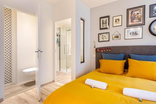 a bedroom with a yellow bed and a bathroom at GuestReady - Modern Comfort in Vincennes in Vincennes