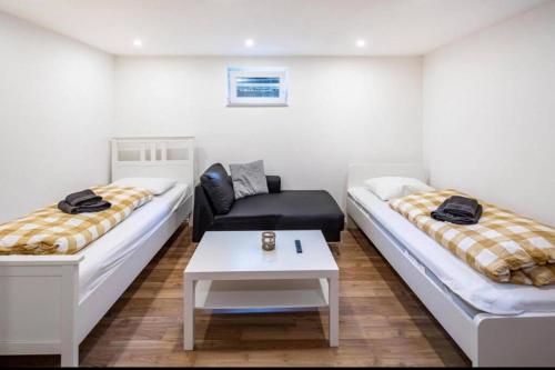 Habitación con 2 camas, sofá y mesa. en CityLoft Kassel 1 - Zentrale Unterkunft für Gruppen bis 7 Personen - Parkplatz - Netflix, en Kassel