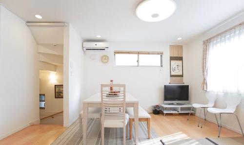 a dining room with a table and chairs and a television at Tokyo Center Ikebukuro Family villa quiet 4BR group stay & parking near JR in Tokyo