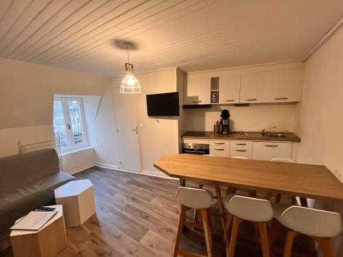 une cuisine et un salon avec une table et des chaises dans l'établissement Appartement Duplex avec Wifi proche du centre, à La Bourboule