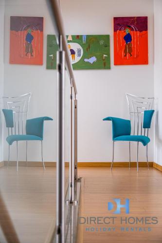a room with chairs and paintings on the wall at Villas Rocha in Albufeira