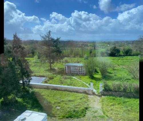 ein Haus mitten auf einem Feld mit einer Straße in der Unterkunft La Longère in Brectouville