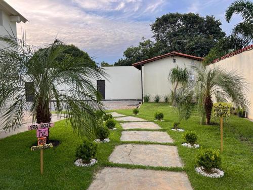 a garden with palm trees and a walkway at POUSADA BELLA CANASTRA in Piumhi