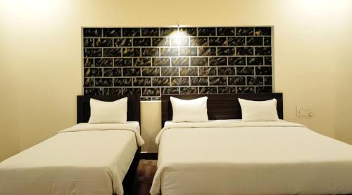 A bed or beds in a room at R Hotels By Suraj Residency Yercaud