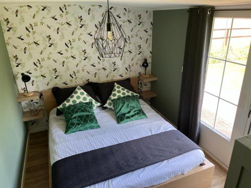 - une chambre avec un lit doté d'oreillers verts et bleus dans l'établissement 't Pothuuske, à Ruurlo