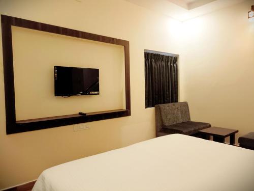 A bed or beds in a room at R Hotels By Suraj Residency Yercaud