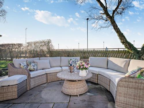 a patio with a couch and a table with flowers at 6 Bed in South Queensferry 94359 in Broxburn