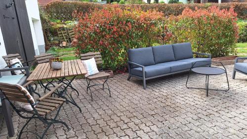 a patio with a couch and chairs and a table at Ferienhaus Hinterlandswald in Schlangenbad