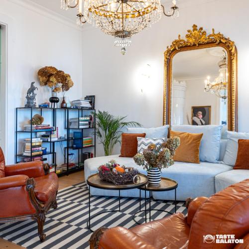 a living room with a blue couch and a mirror at Villa Chez les Amis - Adults only in Balatonszepezd