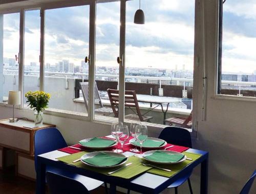 une table avec des assiettes vertes et des verres à vin dessus dans l'établissement Paris Centre, gorgeous panorama, terrace, design, à Paris