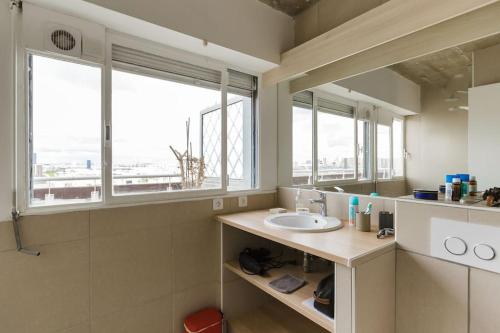 une salle de bain avec un lavabo et deux fenêtres dans l'établissement Paris Centre, gorgeous panorama, terrace, design, à Paris