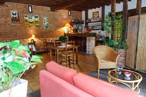 a living room with a pink couch and a bar at Auberge du Manoir d'Archelles in Arques-la-Bataille