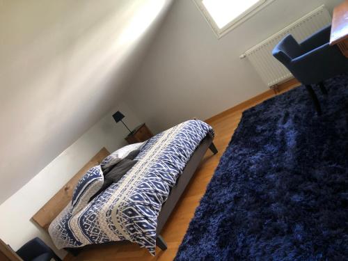 a bedroom with a bed with a blue comforter at Le bleu Levant in Vaux-devant-Damloup