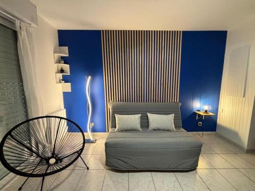 - un salon avec un canapé et un mur bleu dans l'établissement Joli appartement aux Minimes avec Parking, à La Rochelle