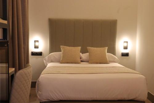 a bedroom with a large white bed with two pillows at Hostal La Rúa-Montera in Madrid