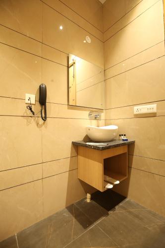 a bathroom with a sink and a mirror at Hotel Nayyar Regency in Amritsar