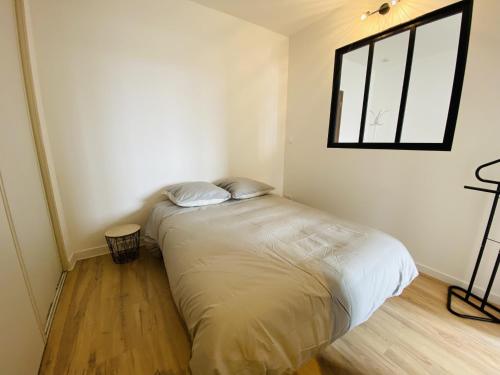 uma cama num quarto com uma janela em Le Soulicou em Rodez