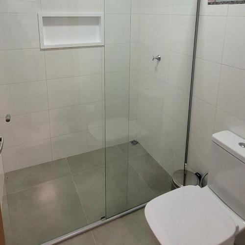 uma casa de banho com uma cabina de duche em vidro e um WC. em Pousada Angatu Jalapão em São Félix do Tocantins