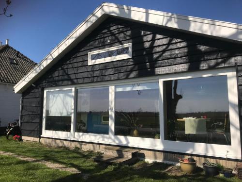 a house with large windows on the side of it at Over Lake in Monnickendam