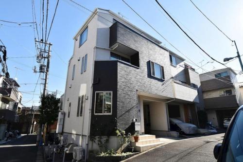 a white and black building on the side of a street at Tokyo Center Ikebukuro Family villa quiet 4BR group stay & parking near JR in Tokyo