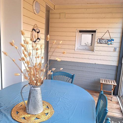une table bleue avec un vase en haut dans l'établissement A seulement 150m plage et commerces maison 90m2 4 pièces avec parking privé et 2 terrasses sud, à Saint-Jean-de-Monts