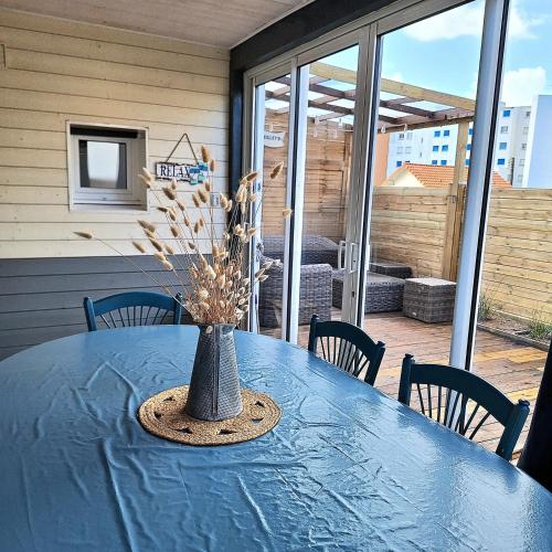 une table bleue avec un vase en haut dans l'établissement A seulement 150m plage et commerces maison 90m2 4 pièces avec parking privé et 2 terrasses sud, à Saint-Jean-de-Monts