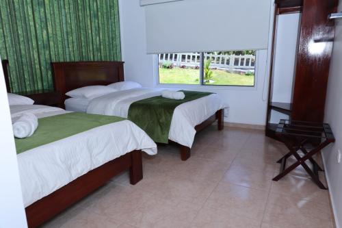 a hotel room with two beds and a window at ROCCA VENTO in Bajo Boquete