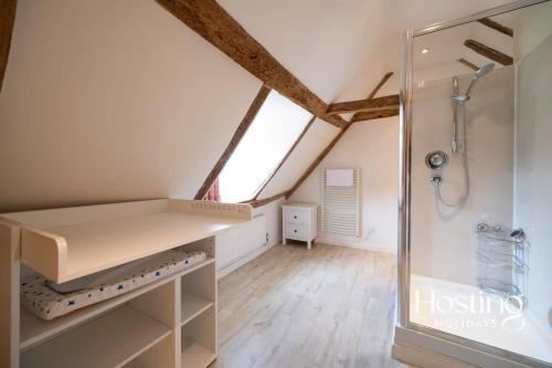 a attic bathroom with a shower and a sink at Bullocks Farm House - 6 Exceptional Bedrooms in High Wycombe