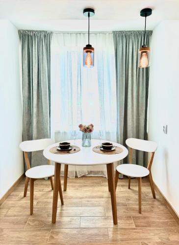 a dining room table with two chairs and a white table at Cozy Spot in Deva