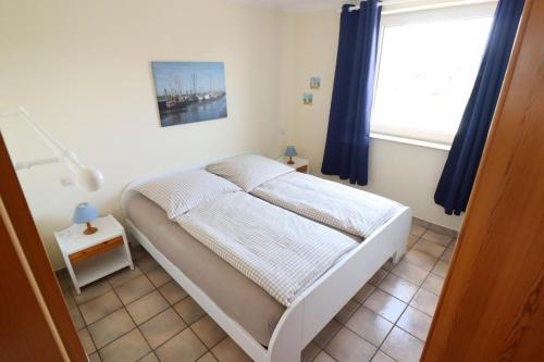 uma cama num quarto com uma janela e uma cama sidx sidx em Horizont-Wohnung-3 em Cuxhaven