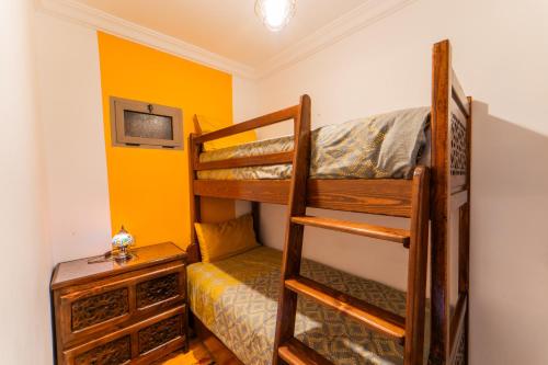 a bedroom with two bunk beds and a tv at Dar Jinane in Chefchaouene