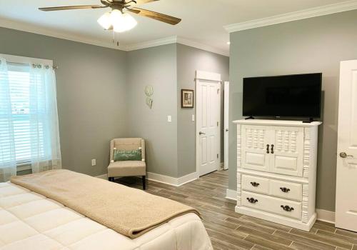 a bedroom with a flat screen tv and a bed at *Chic Beach Cottage Retreat* near Beach/downtown in Gulfport
