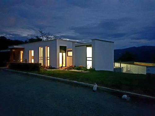 Biały dom na wzgórzu z zapalonymi światłami w obiekcie MANSION PAL SAN GIl w mieście San Gil