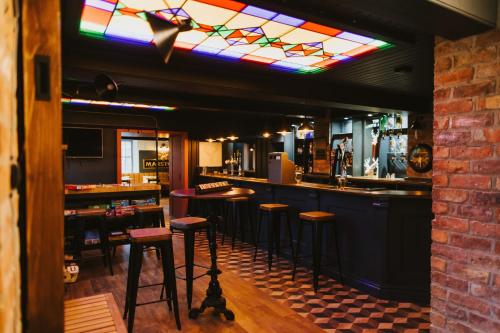 un bar con sgabelli e soffitto in vetro colorato di The White Hart a Brigg