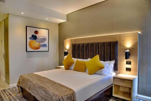 1 dormitorio con 1 cama grande con almohadas amarillas en Luxury Apartment Sandton , NO Loadshedding en Johannesburgo