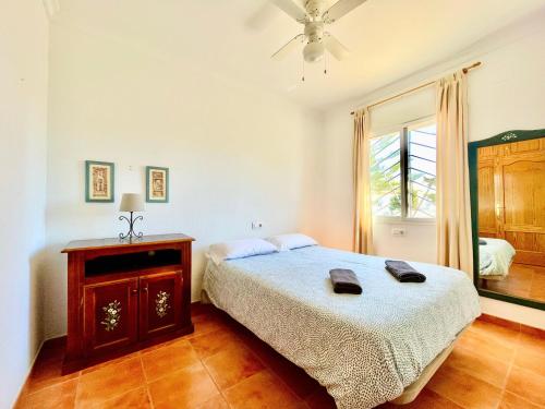 a bedroom with a bed and a dresser and a window at Casa Boga - Urbasur in Islantilla