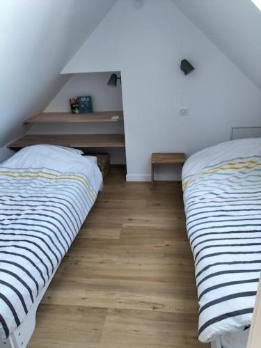 deux lits côte à côte dans une chambre dans l'établissement Coté Golfe - Golfe du Morbihan, à Sarzeau