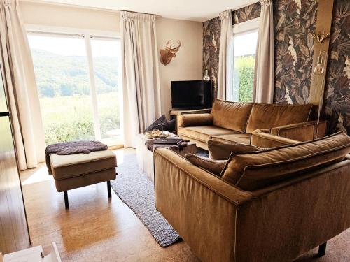 a living room with a couch and a television at O'Blanche, Viroinval Treignes in Treignes