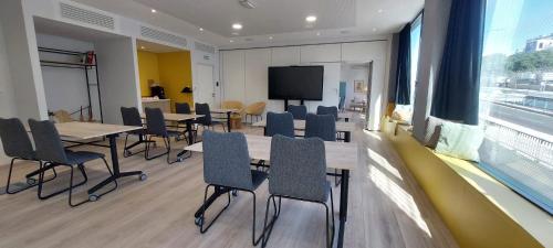 a conference room with tables and chairs and a tv at Crowne Plaza - Marseille Le Dôme in Marseille