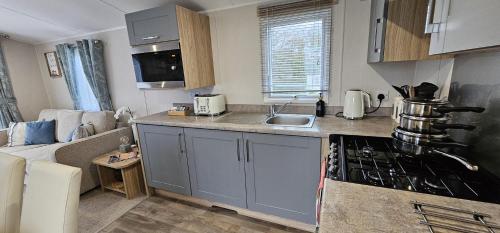 a kitchen with a sink and a counter top at Beautiful Caravan With Decking Wifi At Isle Of Wight, Sleeps 4 Ref 84047sv in Porchfield