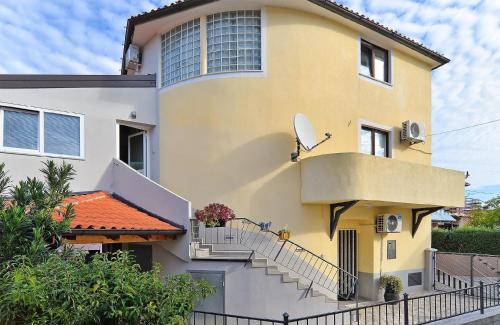 une maison jaune et blanche avec des escaliers. dans l'établissement Ferienwohnung für 6 Personen ca 45 qm in Pomer, Istrien Istrische Riviera, à Pomer