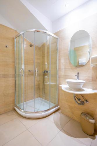 a bathroom with a glass shower and a sink at Kymata Hotel in Naxos Chora