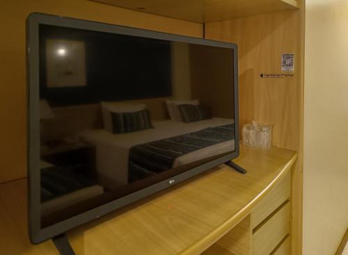a large flat screen tv sitting on a wooden counter at Reymar Hotel Maceió in Maceió