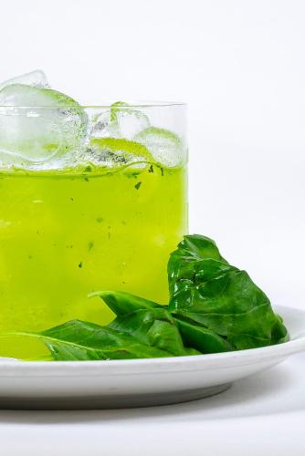 a glass of green tea with leaves on a plate at Hotel Villa Rita in Paestum