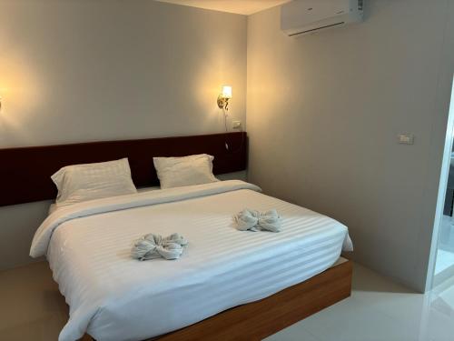 ein Schlafzimmer mit einem Bett mit zwei Bögen darauf in der Unterkunft เอสซีใสวัฒนา in Ban Don Rak