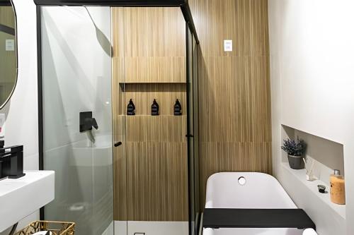 a small bathroom with a toilet and a shower at Lindo loft c/ banheira no Leblon in Rio de Janeiro