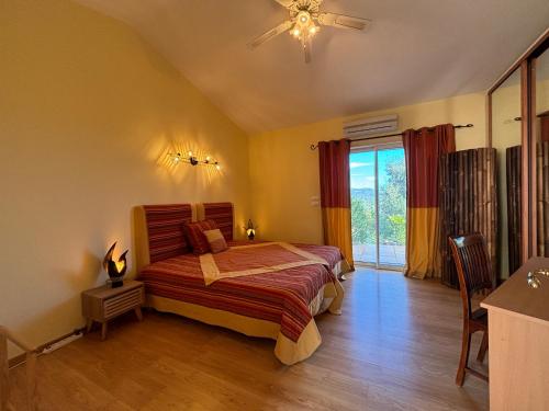 a bedroom with a bed and a ceiling fan at Villa Porto Vecchio in Porto-Vecchio