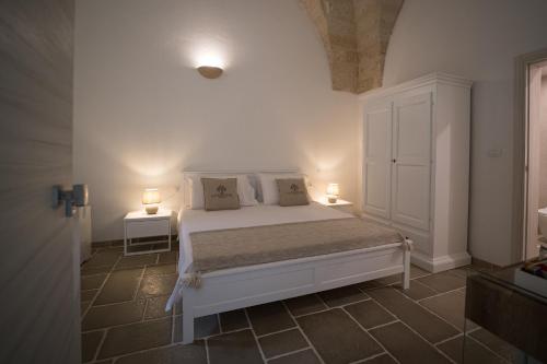 ein Schlafzimmer mit einem weißen Bett und zwei Lampen in der Unterkunft Guerrieri Suites & Spa in Campi Salentina